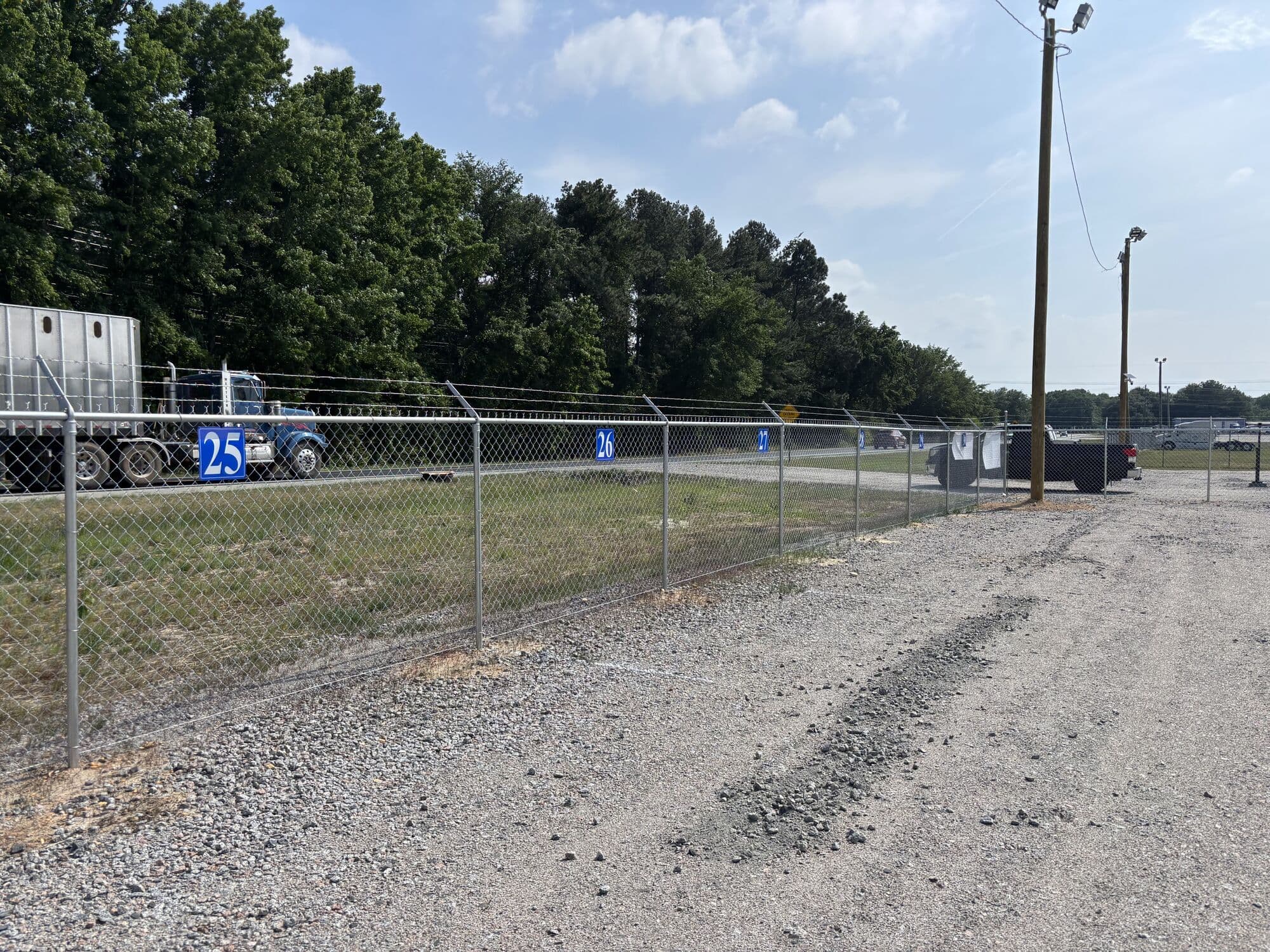 Numbered parking spaces along the fenced perimeter at Legacy Outdoor Storage
